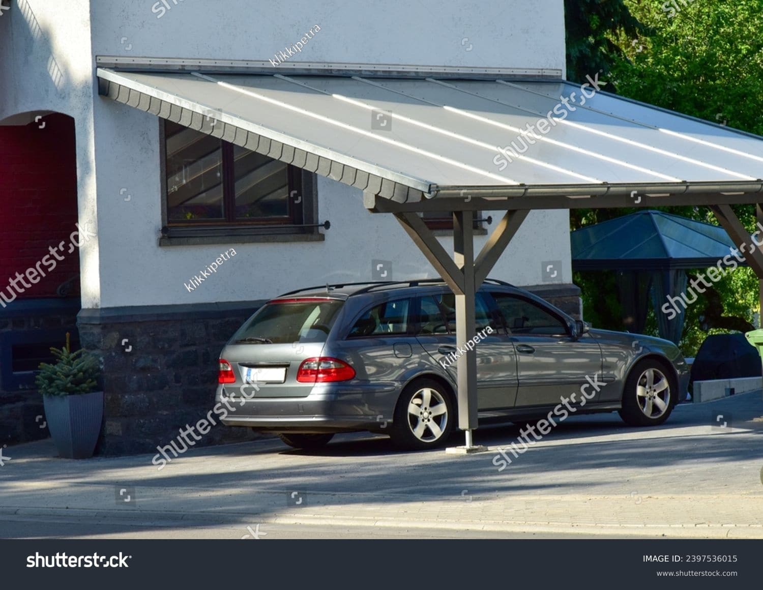 stock-photo-carport-of-varnished-wood-in-front-of-a-residential-building-2397536015